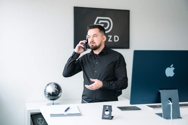 Ioan Drozd telefoniert im Büro, im Hintergrund das Drozd-Logo