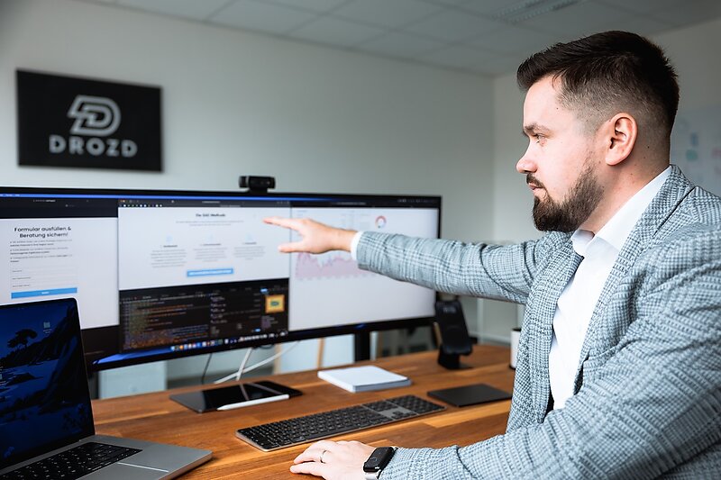 Ioan Drozd zeigt auf ein Dashboard mit Recruiting-Kennzahlen